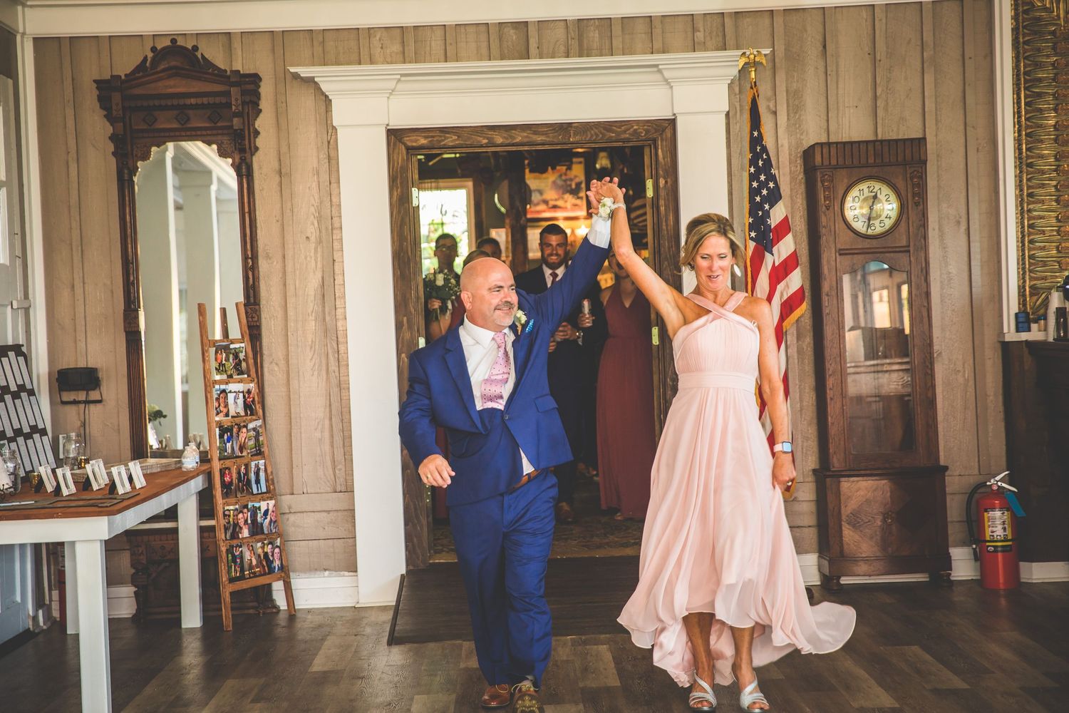 Wedding party gathered in an elegant indoor venue with wood paneled walls and decorative lighting.