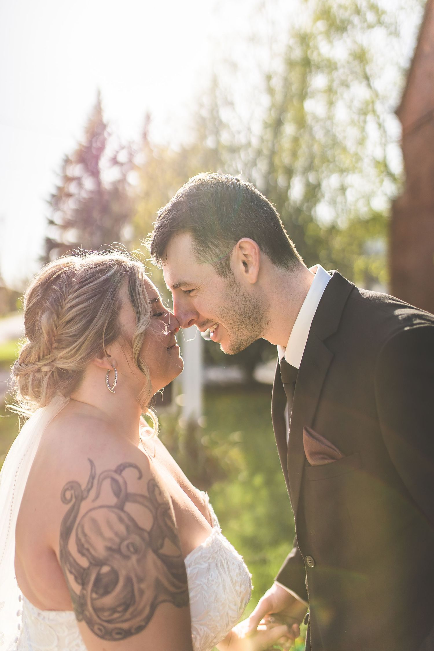 Sunlit wedding portraits with beautiful backlit glow and visible tattoo art.