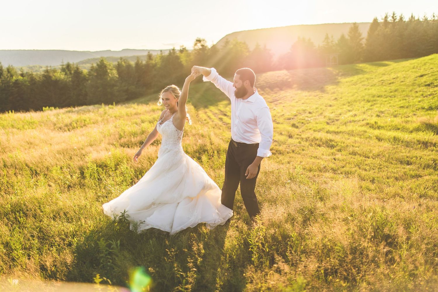 Sunset wedding photography session in a scenic mountain field.