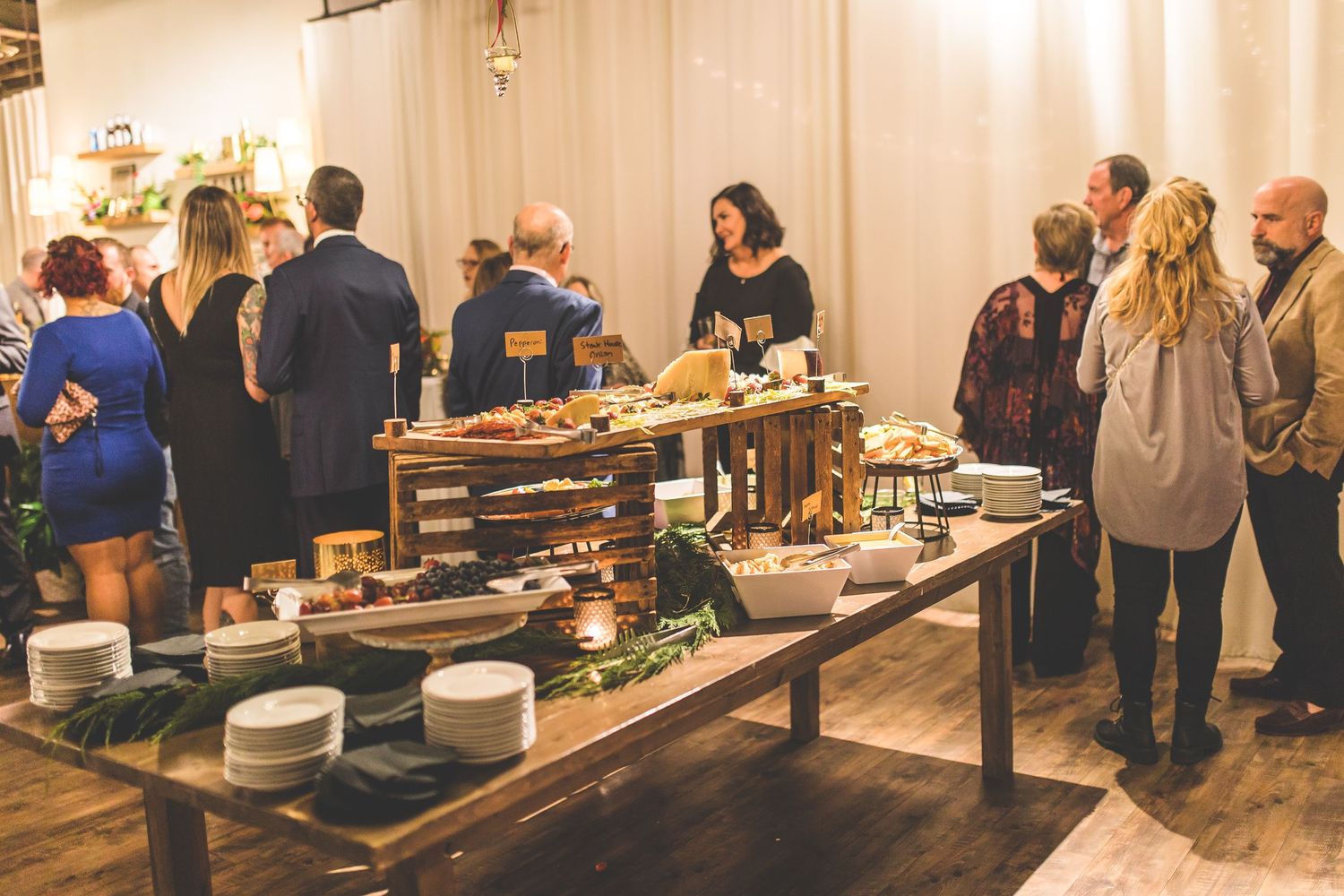 Buffet tables lined with food and decorations at an indoor wedding reception.