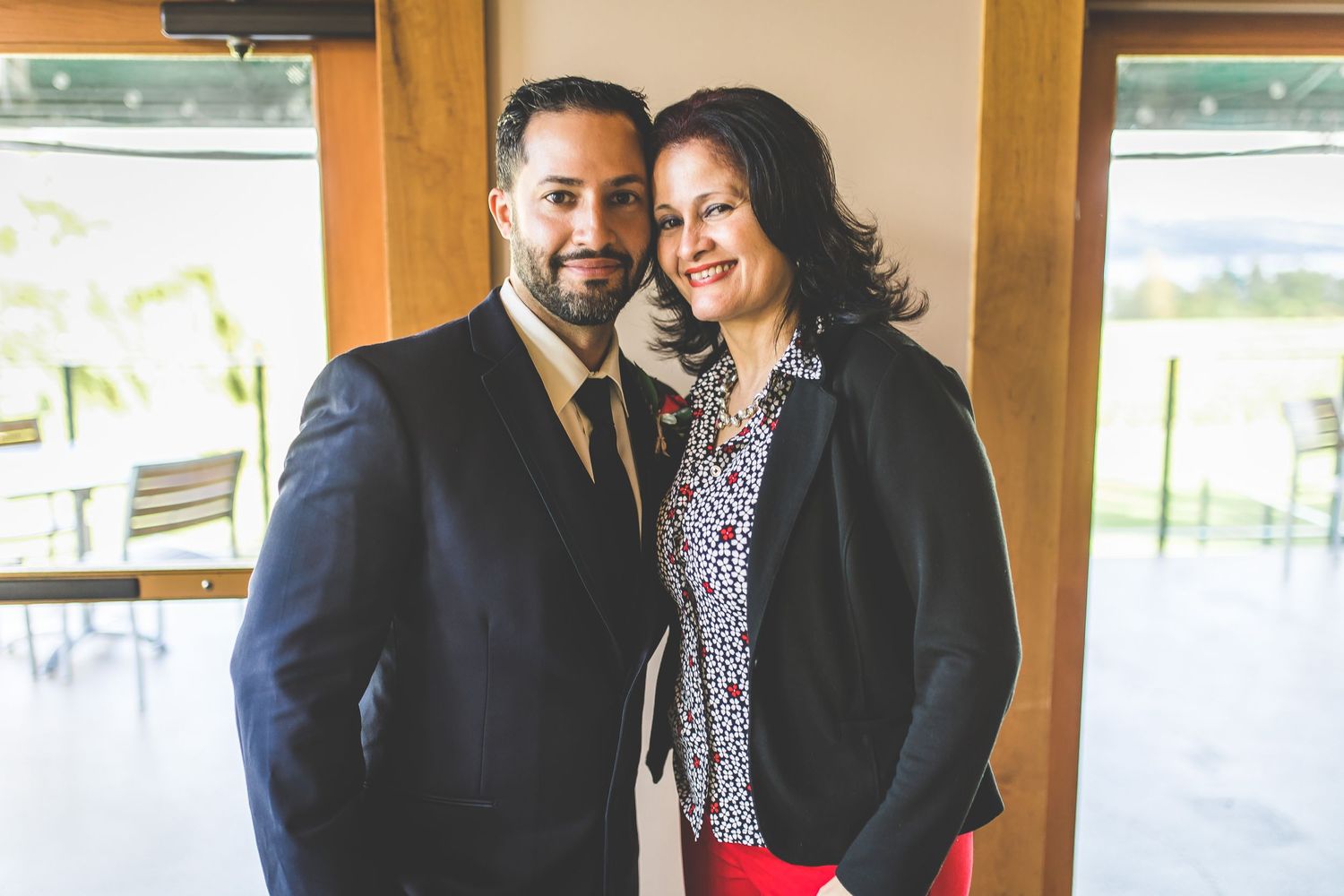 Wedding celebration with guests gathered in a bright indoor venue with wooden accents.