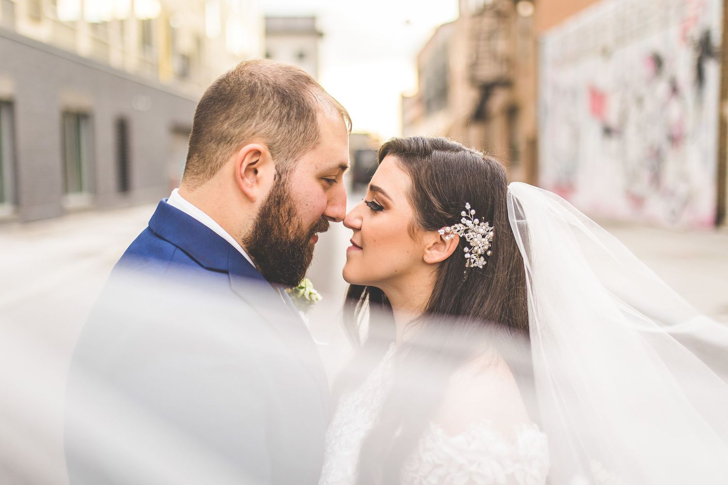 Close-up wedding portraits showing intimate moments between bride and groom on city street.