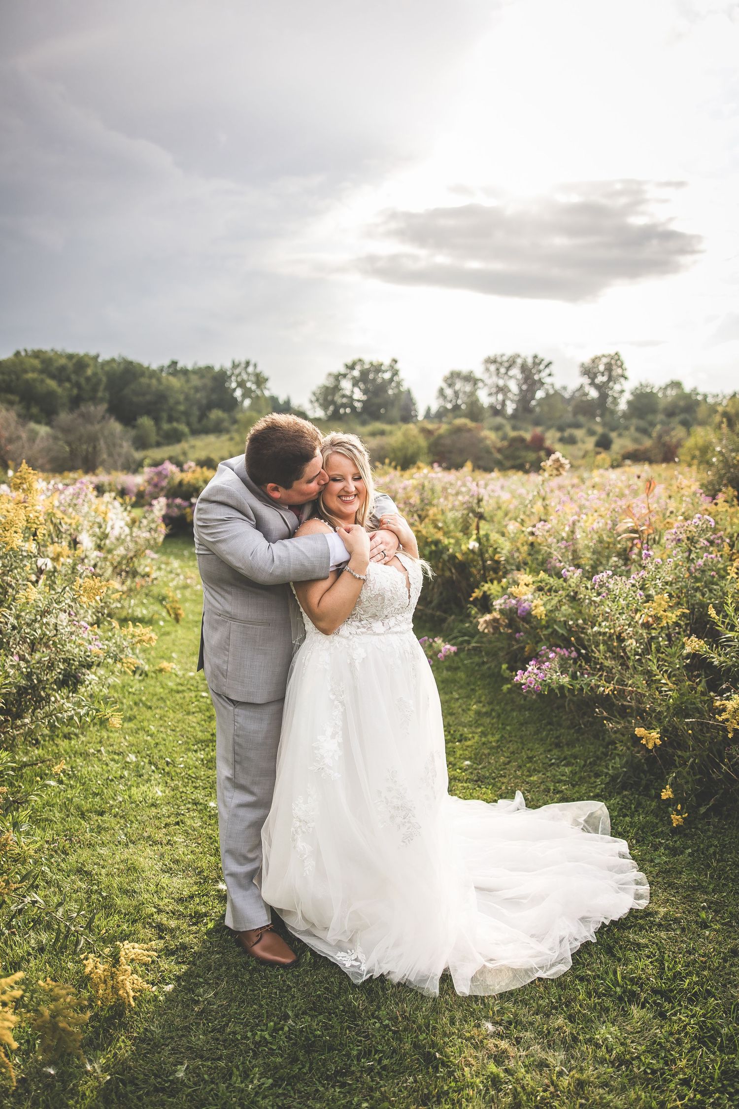 A couple shares tender moments in a field of wildflowers during their wedding celebration.
