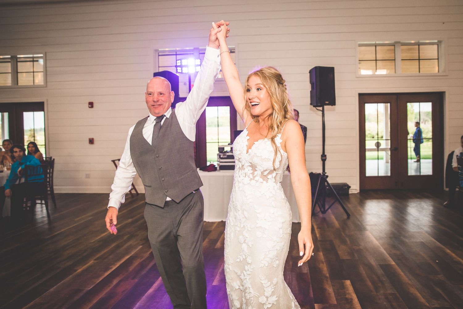 Wedding reception dance floor with romantic lighting and white interior walls.