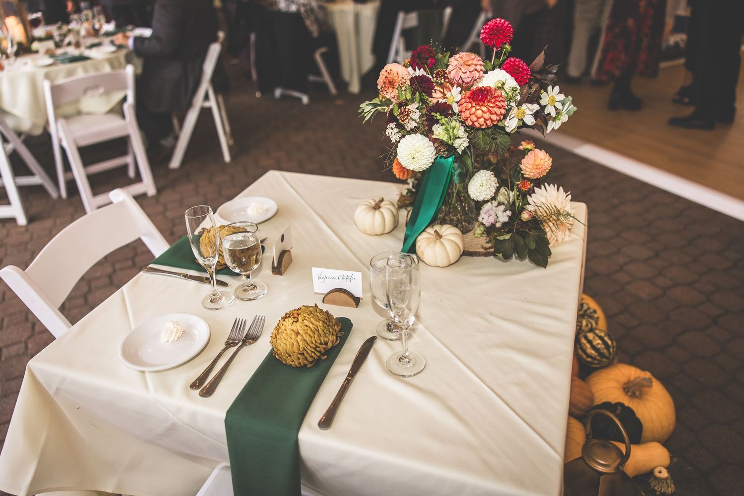 Elegant wedding reception tables set with white linens and floral centerpieces.