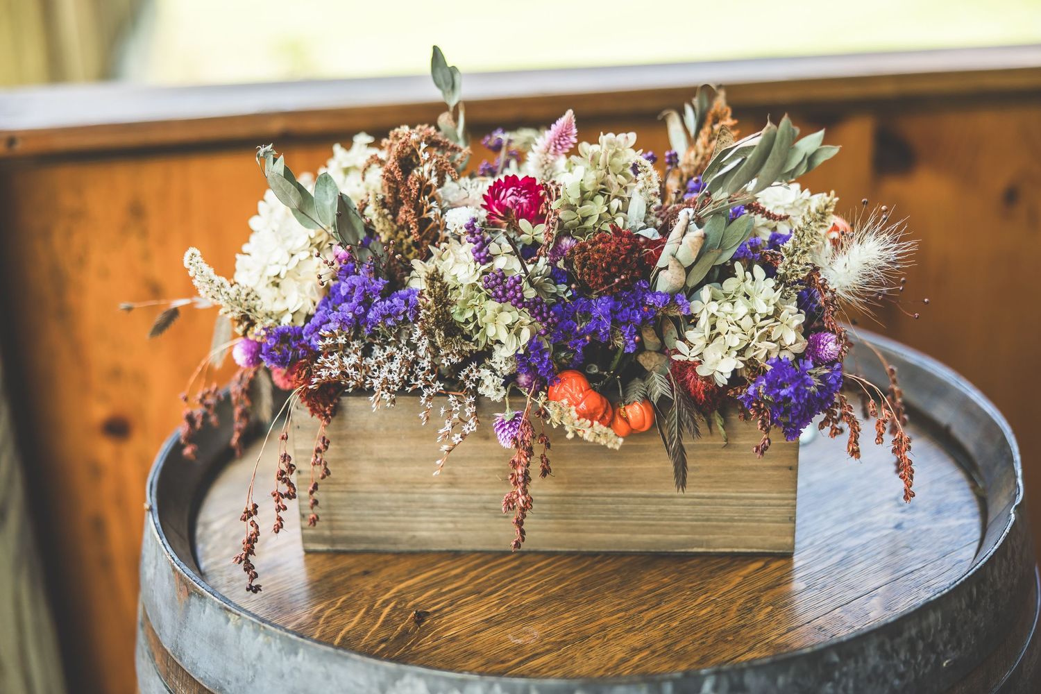 Rustic wooden table decorated with colorful dried flower arrangements and vintage decor.
