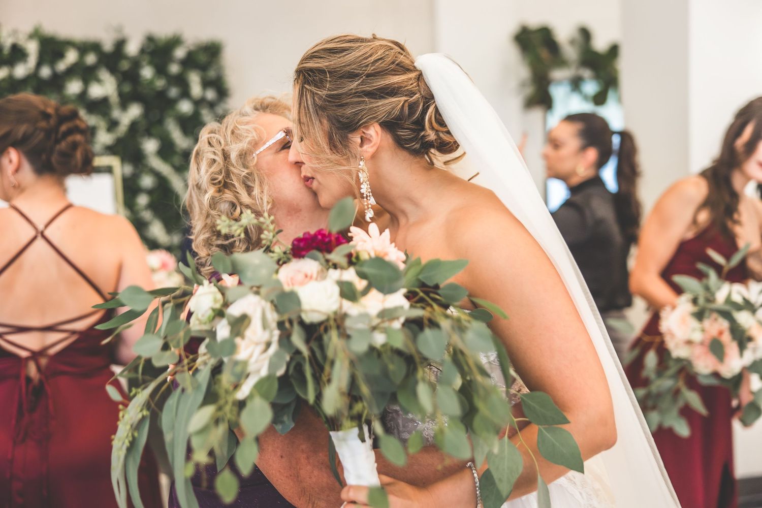 Wedding party poses together with greenery and floral decorations.