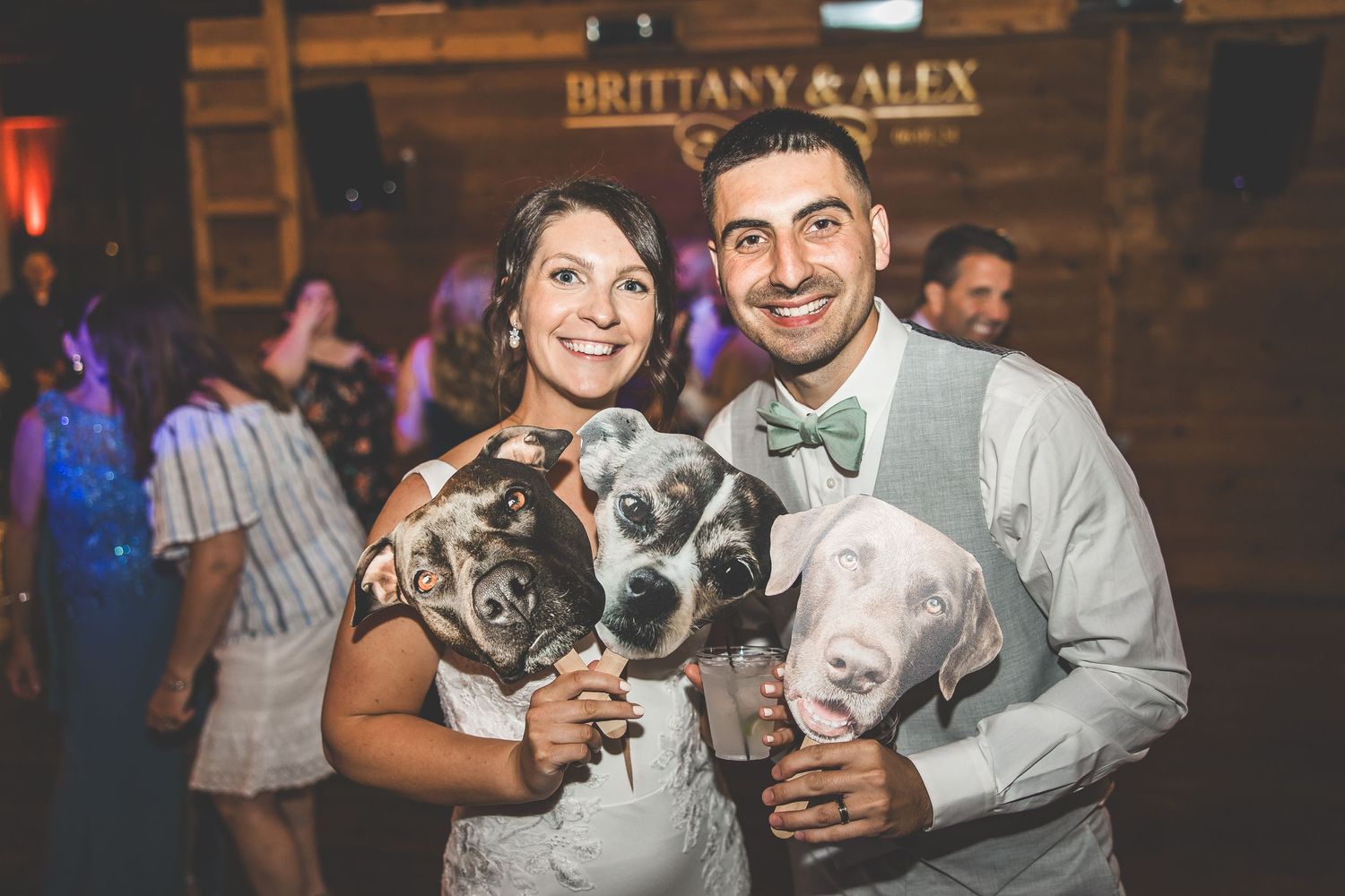 Wedding celebration with fun props and dancing in a rustic barn setting.
