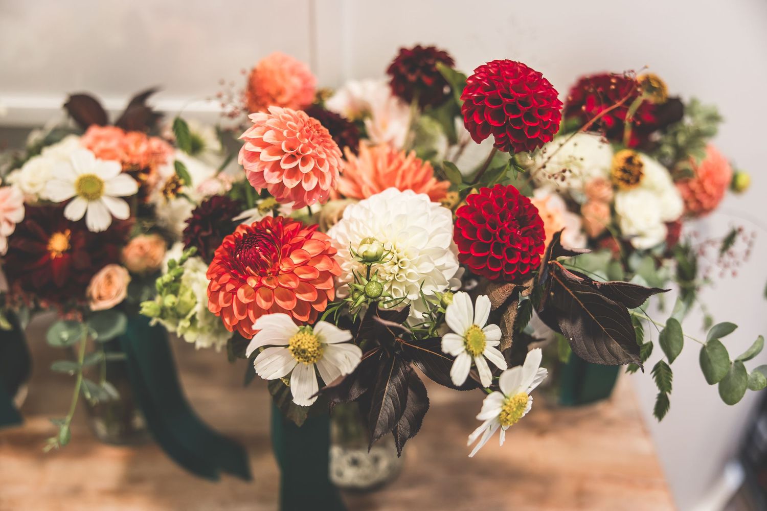 Beautiful floral arrangement with red, pink and white flowers creating an elegant wedding centerpiece.