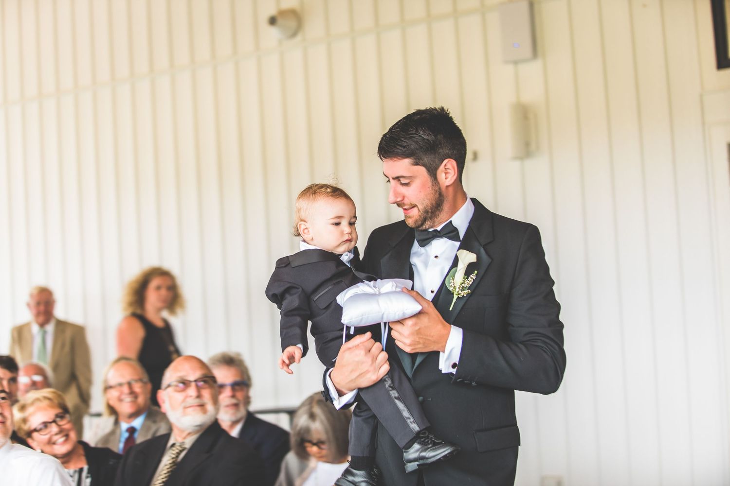 Wedding guests watching an emotional ceremony in an indoor venue.