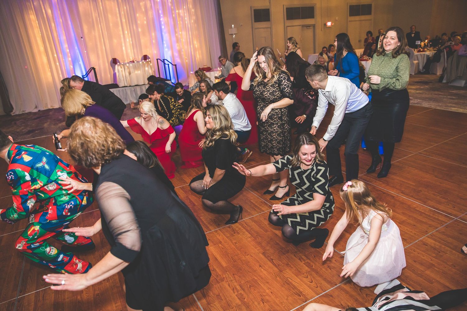 Wide view of a wedding reception dance floor with guests celebrating.