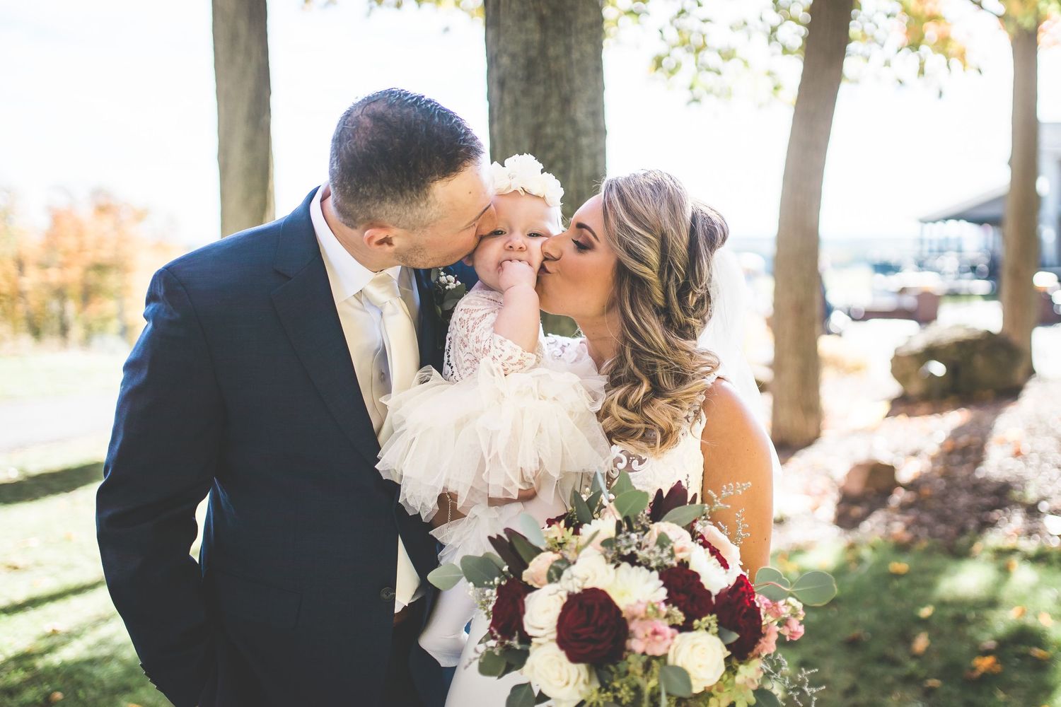 Intimate wedding portraits captured under autumn trees with natural lighting.