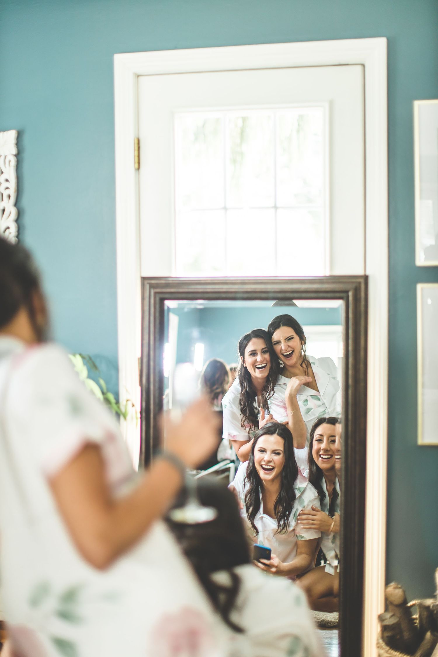 Getting ready room scene with turquoise walls and bright natural window light.