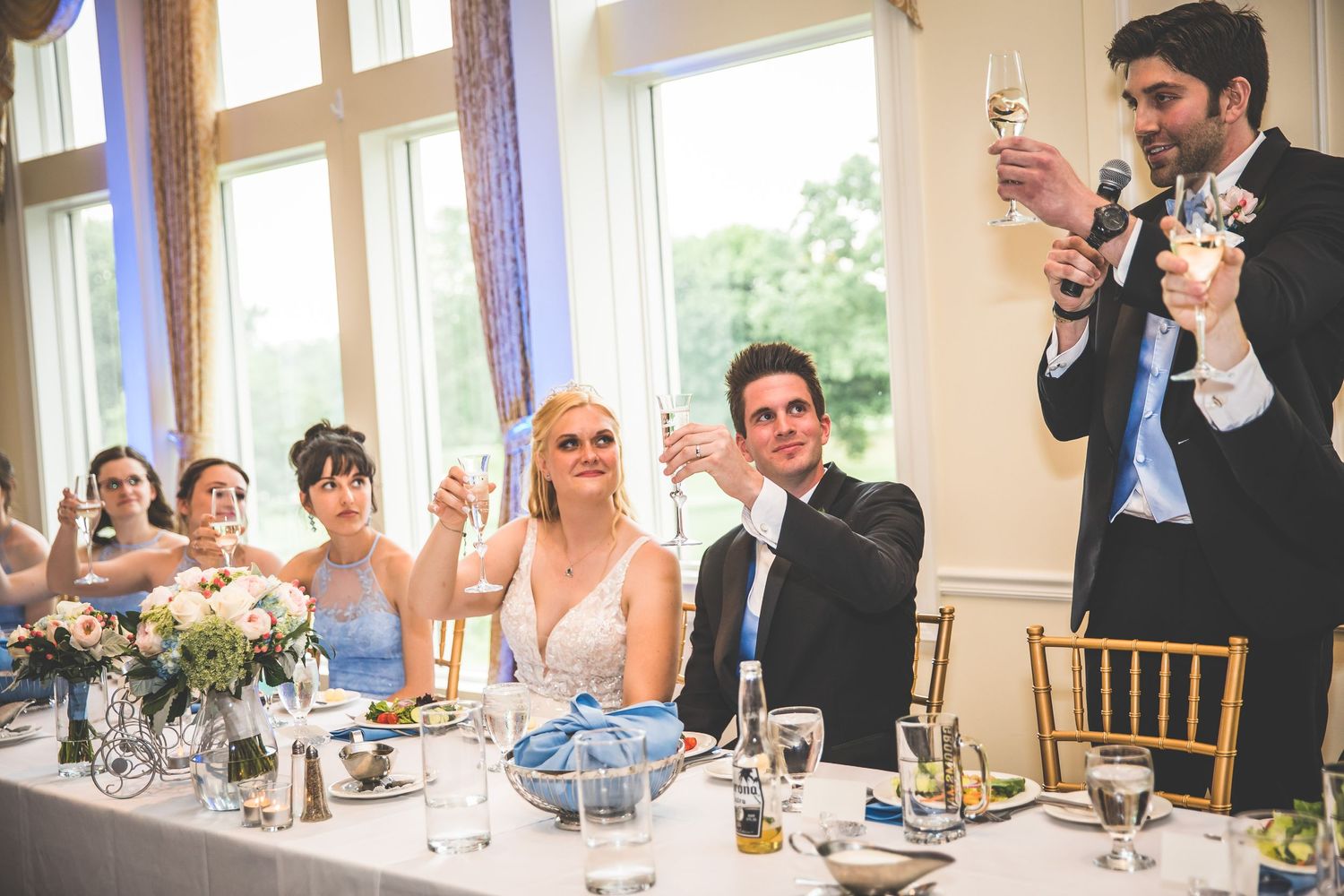 Elegant wedding reception table setting with guests enjoying dinner and conversation.