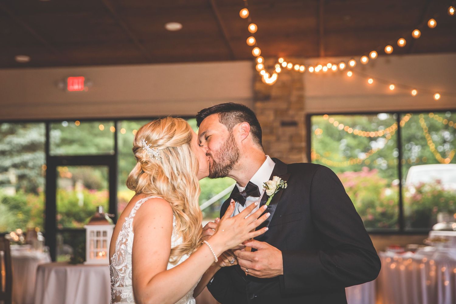 Wedding reception venue with romantic string lights and elegant table settings.