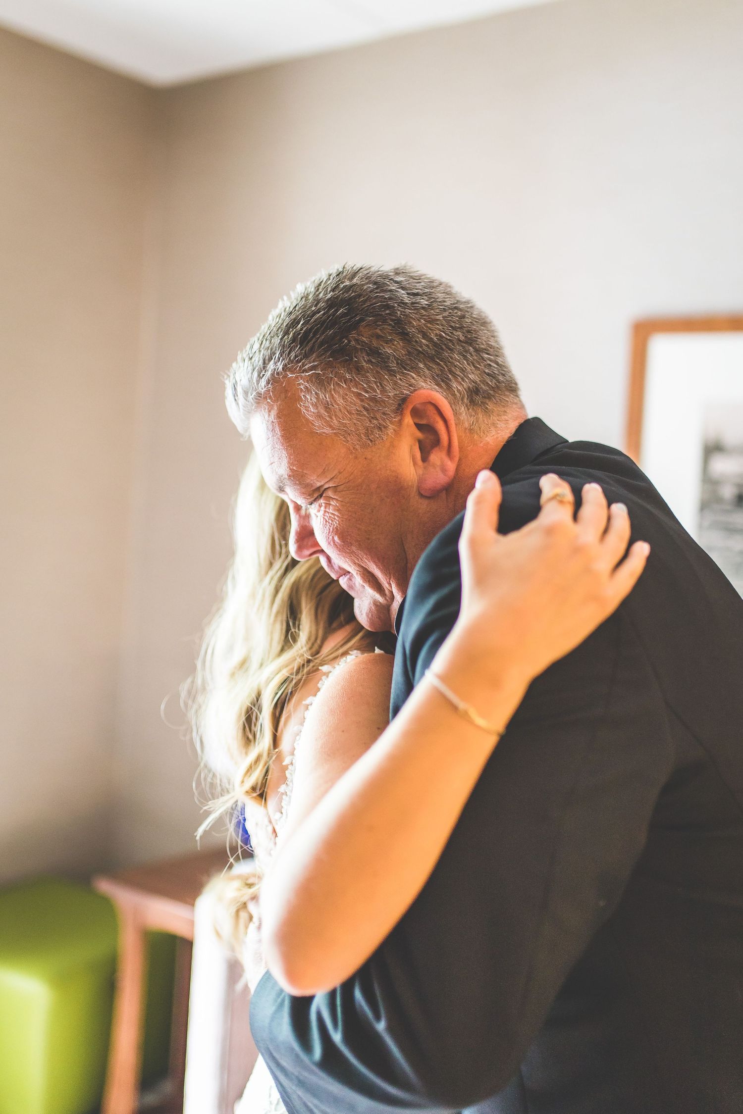 An emotional embrace between a person in formal attire and someone in a wedding dress.