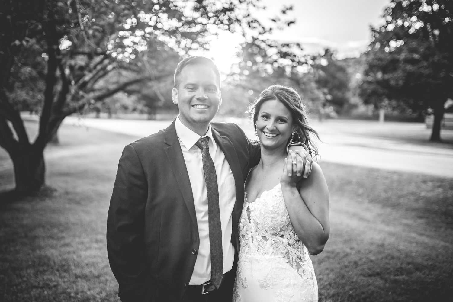 Black and white wedding photography series on a scenic outdoor lawn.