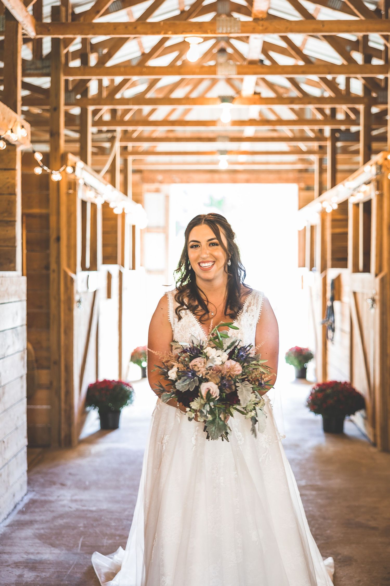 Rustic barn wedding venue with exposed wooden beams and natural lighting streaming through.