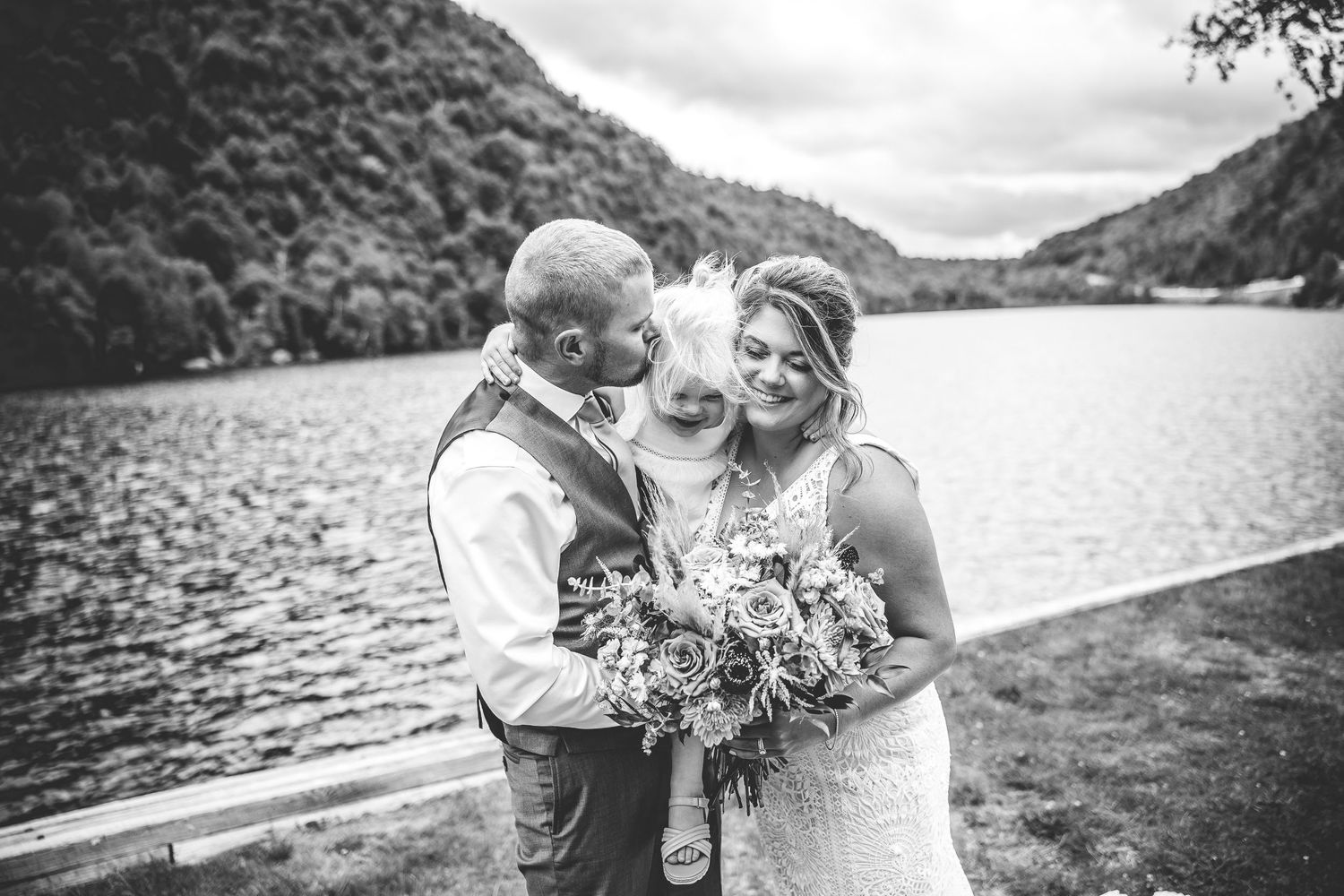 Black and white wedding photos captured beside a serene mountain lake.