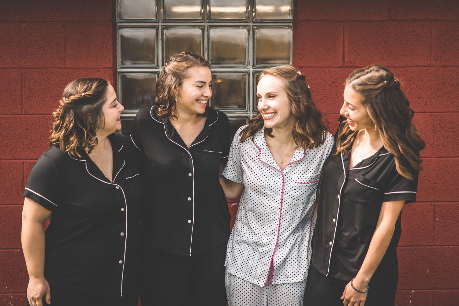 Group photo session against red brick wall background.