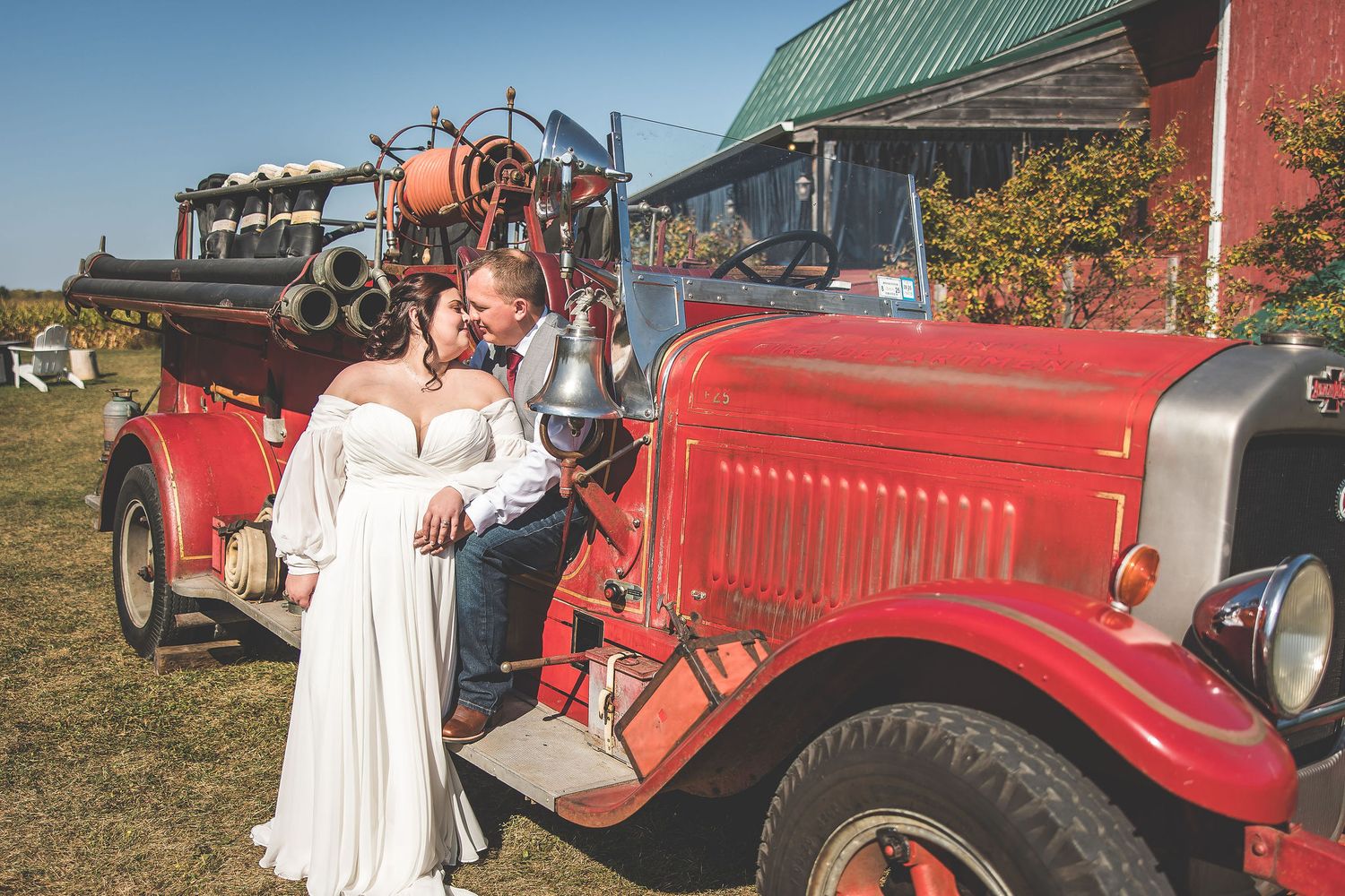 Wedding photos incorporating vintage red fire truck at rustic barn venue.
