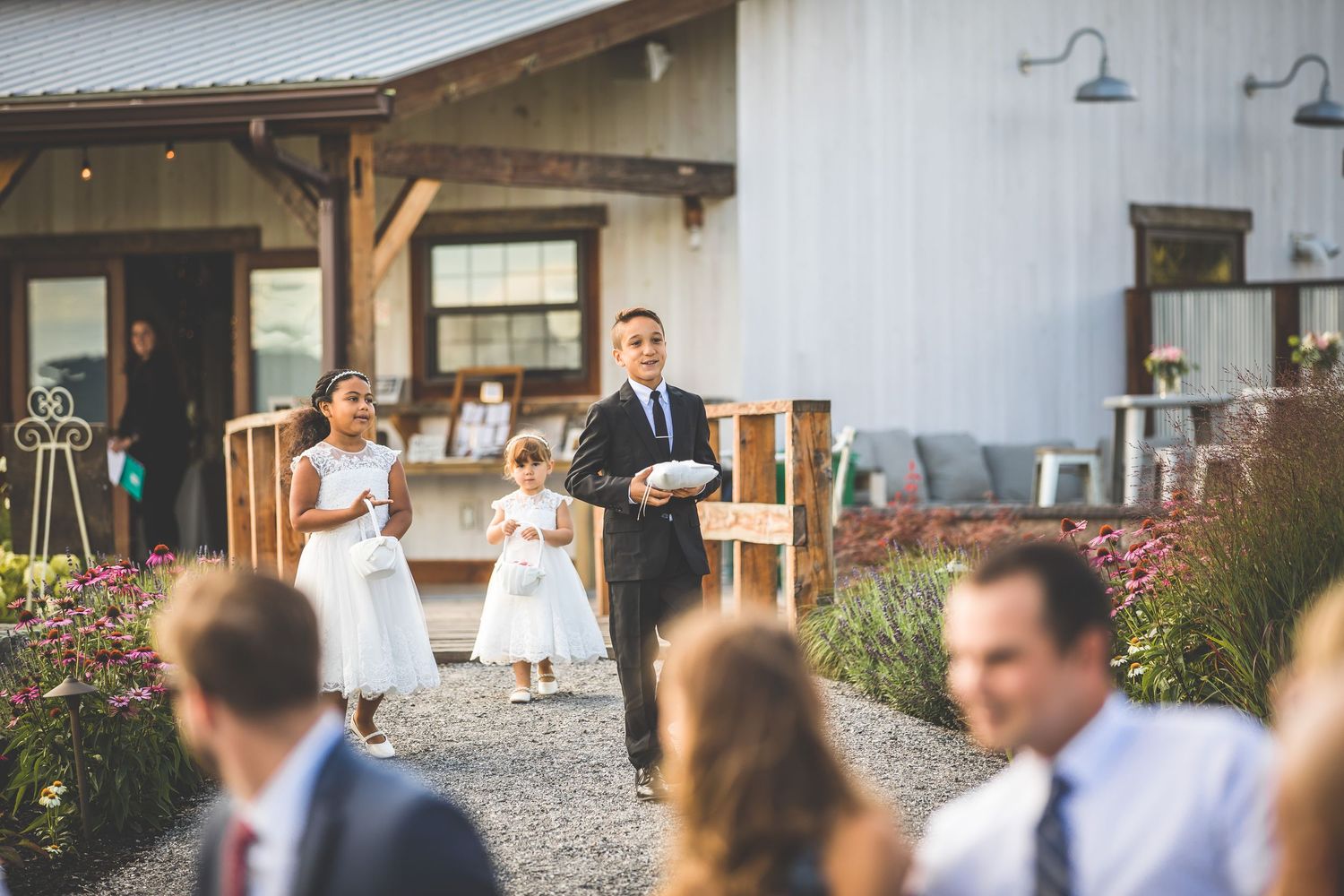 Exterior view of a white barn wedding venue with rustic architectural details.