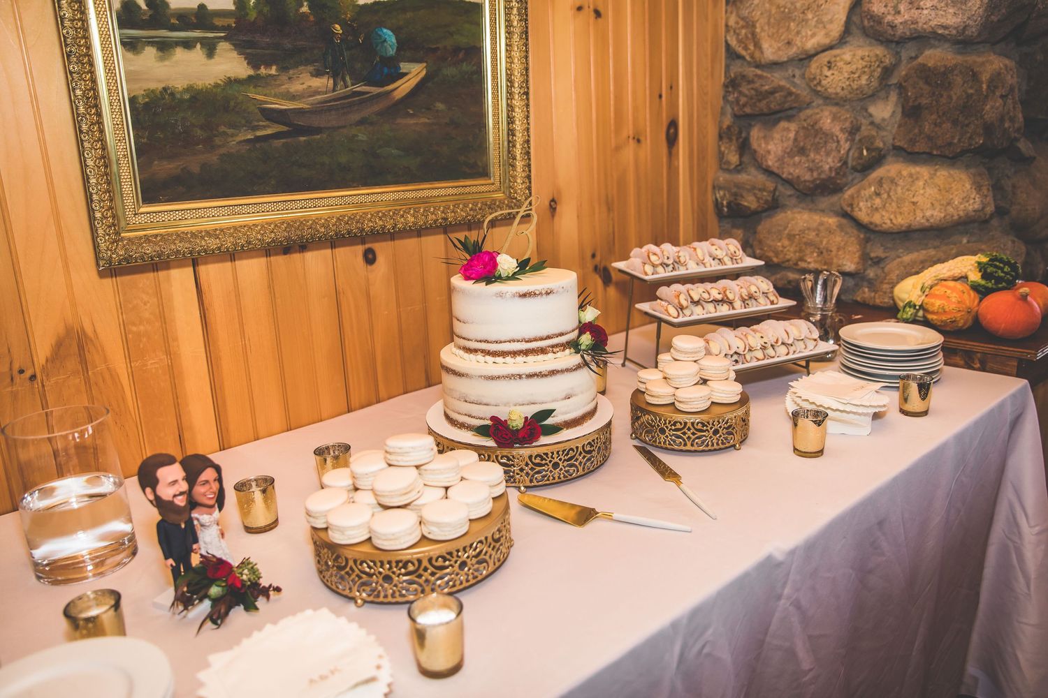 Wedding reception table decorated with candles and rustic decor against a stone wall.