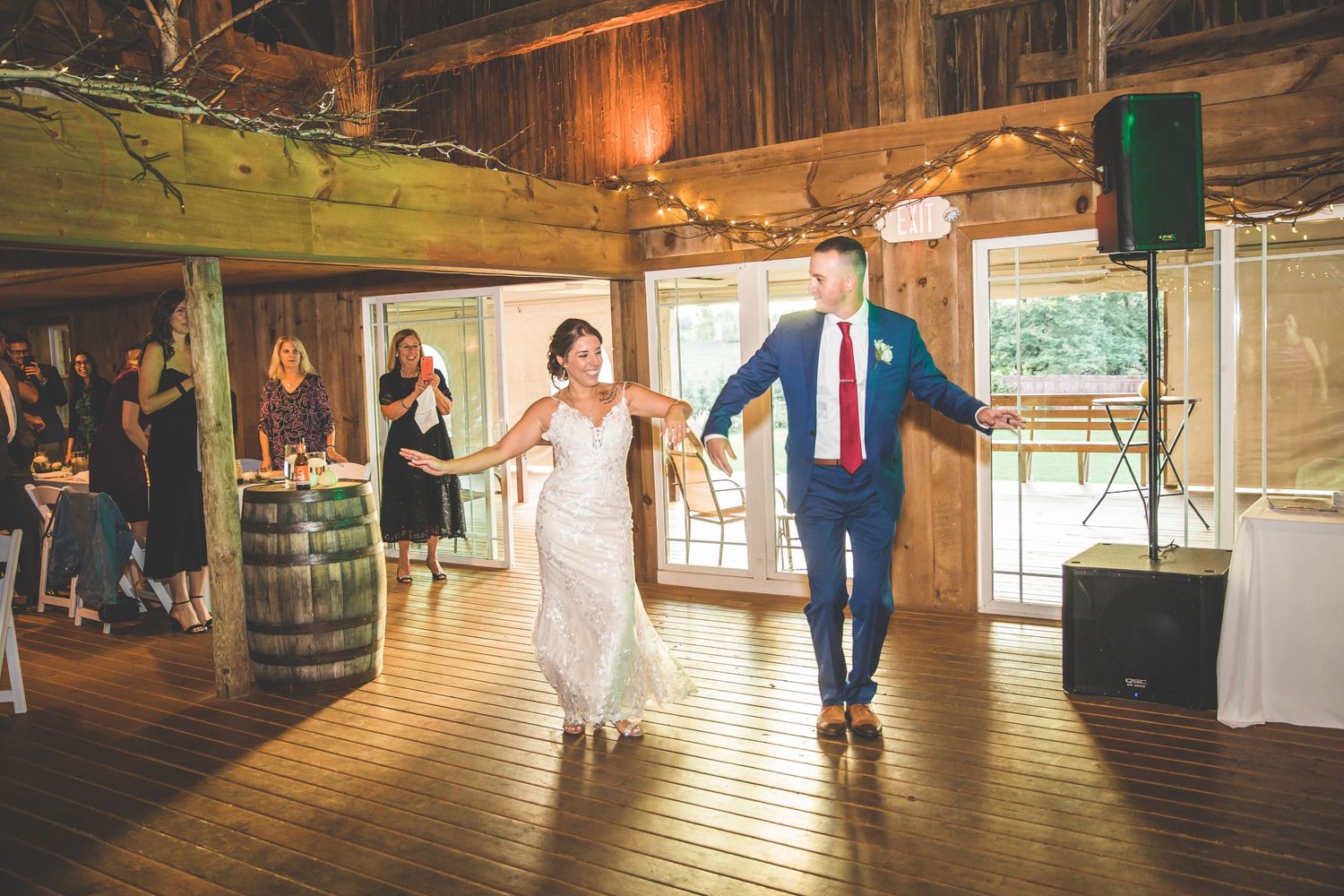 Wedding celebration in a rustic barn venue with wooden beams and natural lighting.