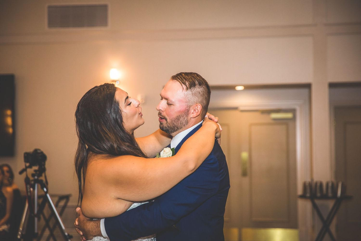 Couple sharing their first dance at an elegant indoor wedding reception.