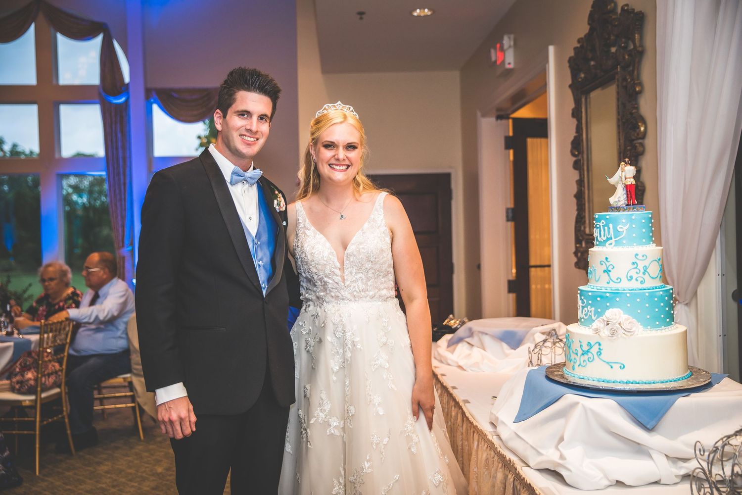 A couple shares their first dance at their wedding reception in an elegantly lit ballroom.