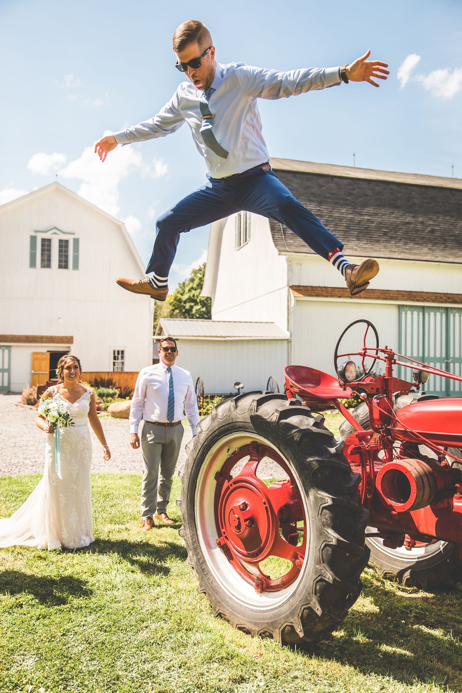 Playful wedding photos with vintage red tractors on a farm.