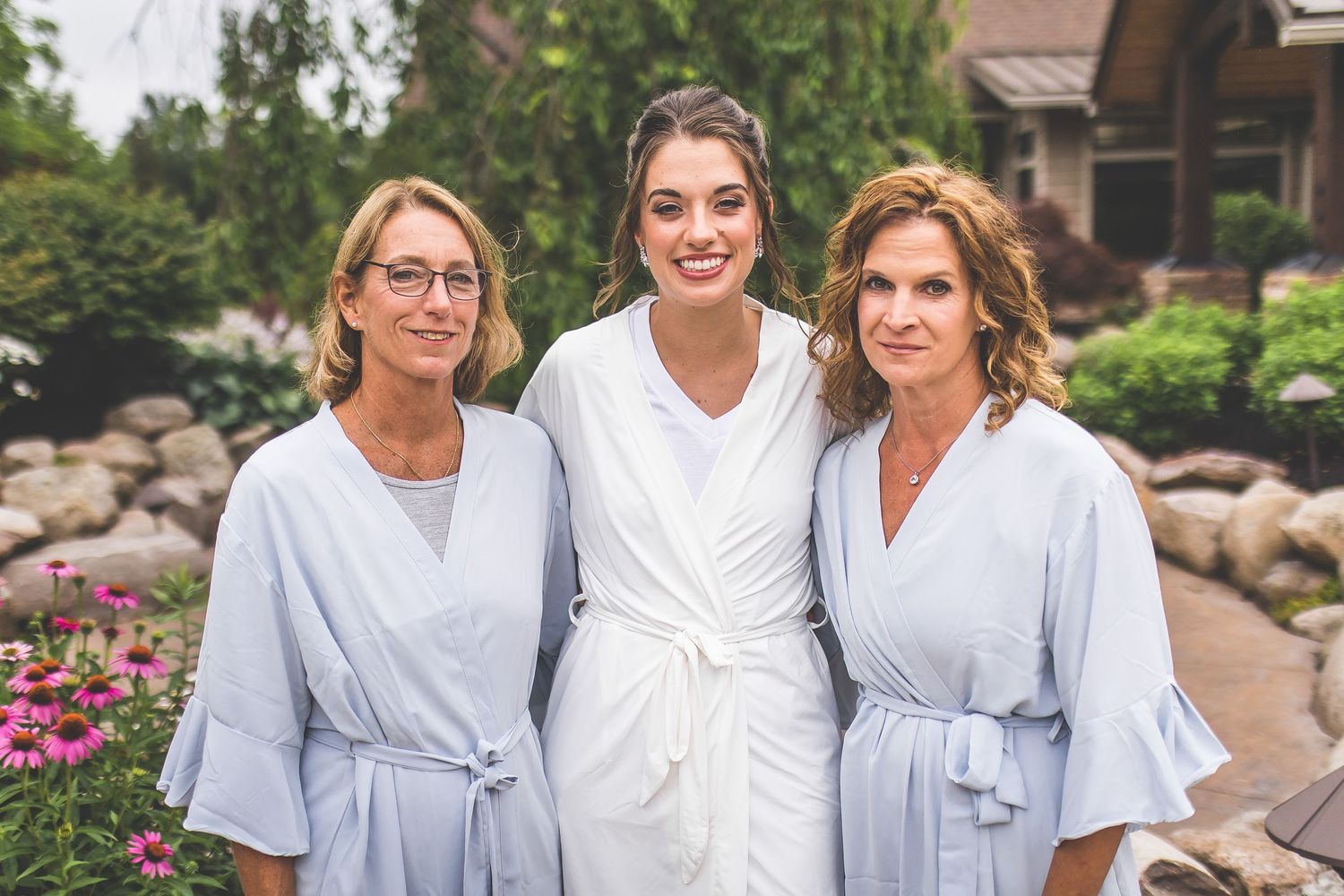 Group photo of wedding party members in coordinated blue and white attire.