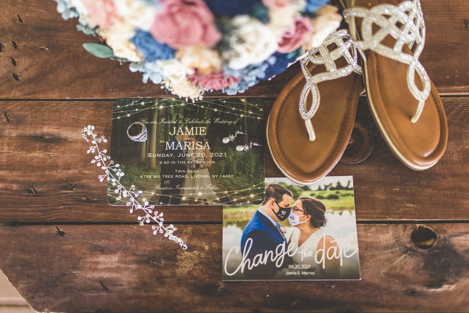Wedding details including floral arrangements and invitations on rustic wooden surface.