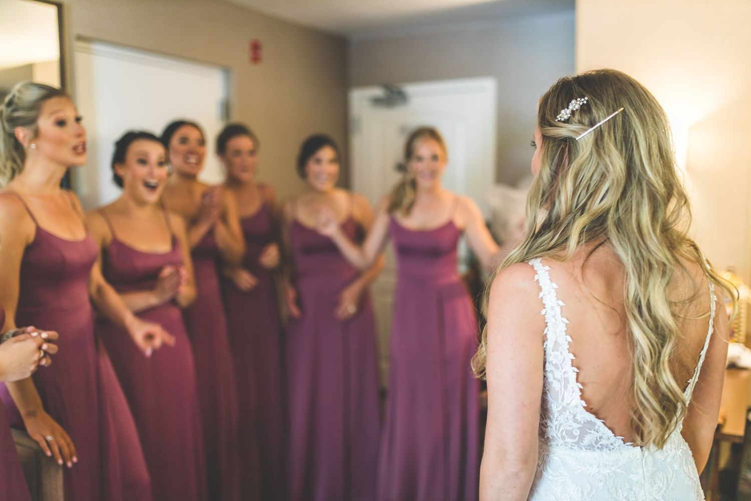 Bridesmaids in purple dresses line up during wedding preparations.