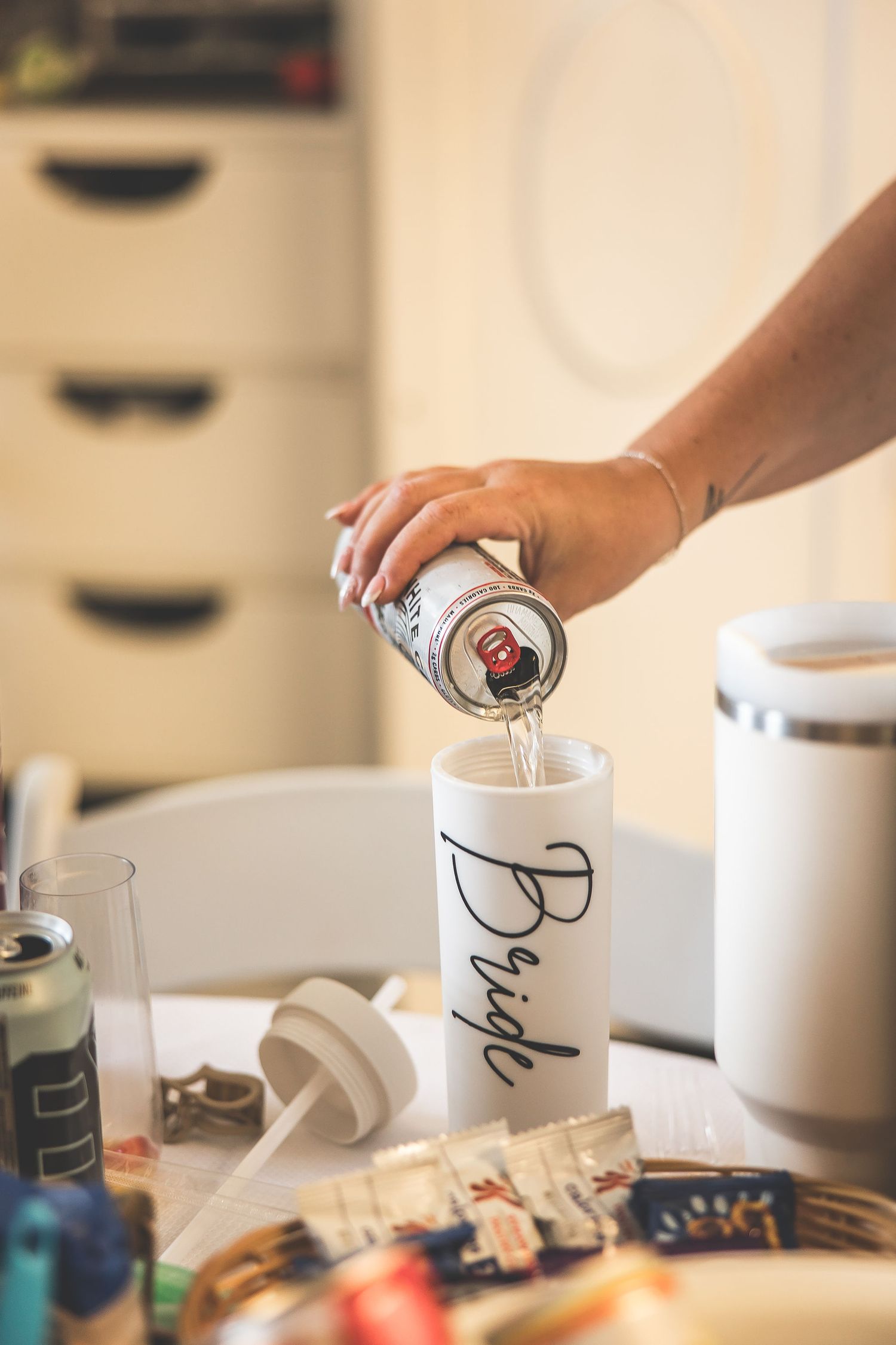 Decorated coffee mugs and wedding day preparation items arranged on a table.