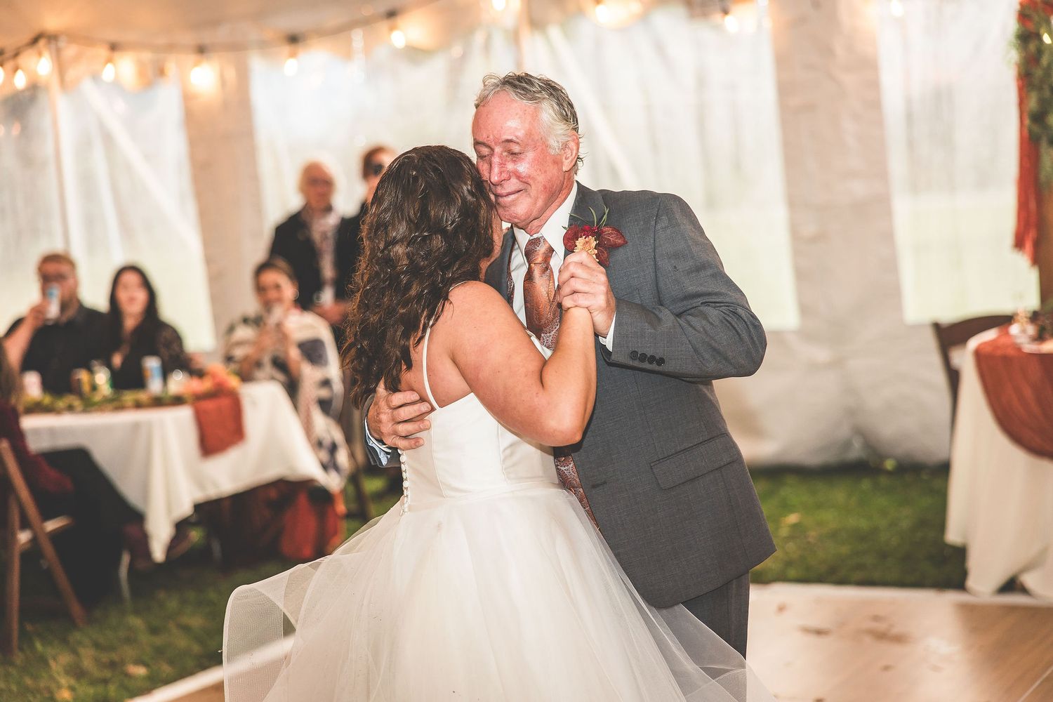 Romantic dance sequence at wedding reception with string lights creating warm ambiance.