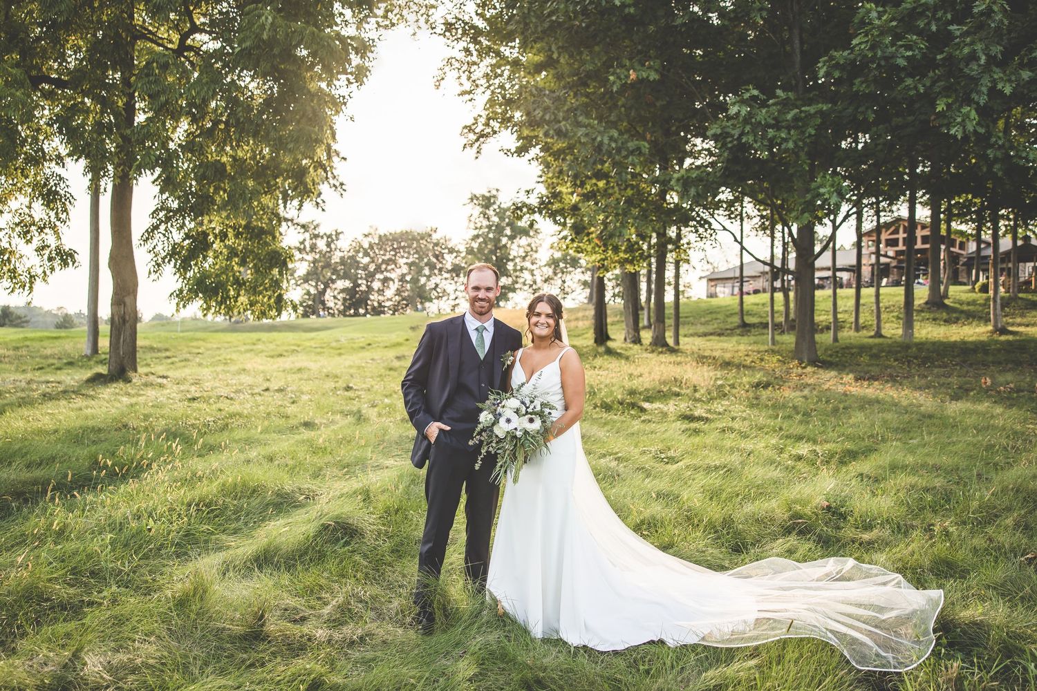 Romantic wedding photos captured in a sunlit outdoor setting with flowing white dress.