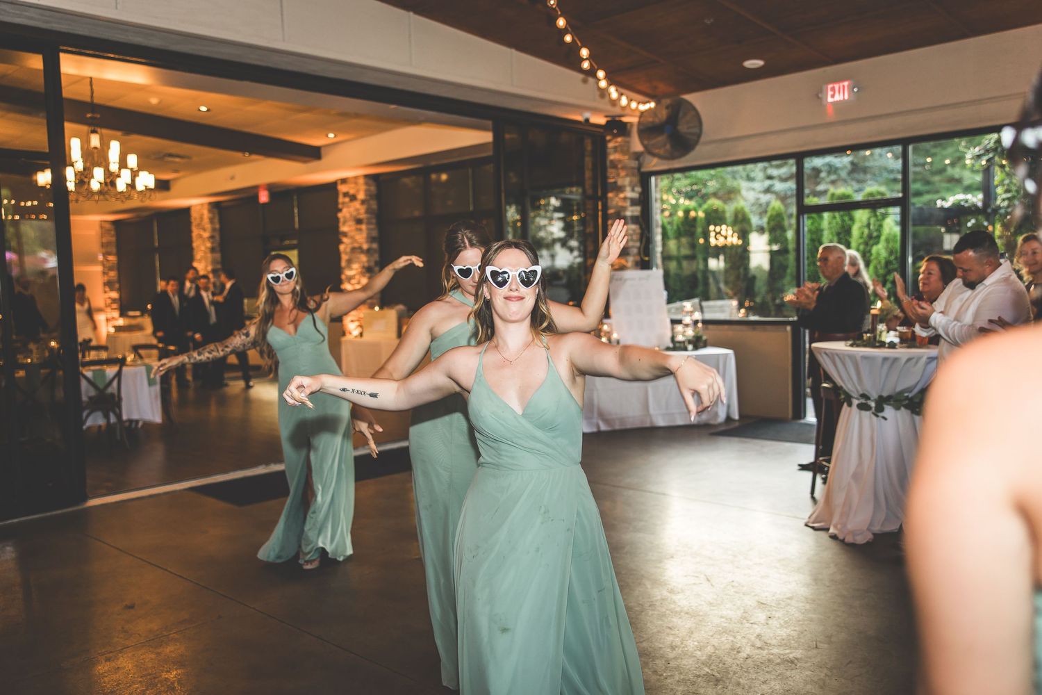 Wedding reception dance floor with guests in mint green dresses enjoying the celebration.