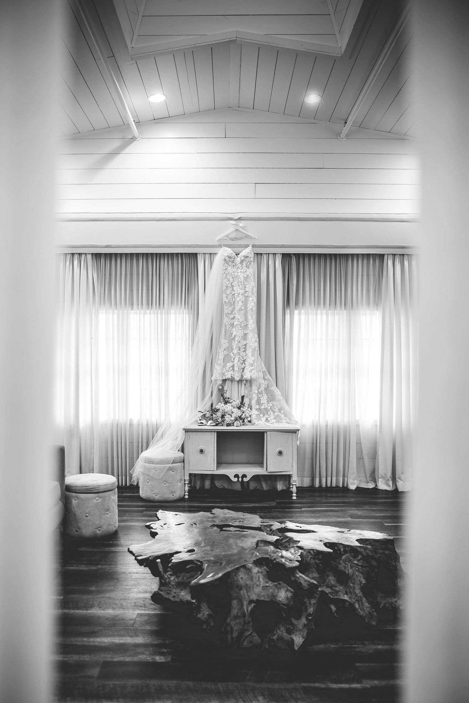Modern white wedding venue interior with dramatic lighting and draped fabric.