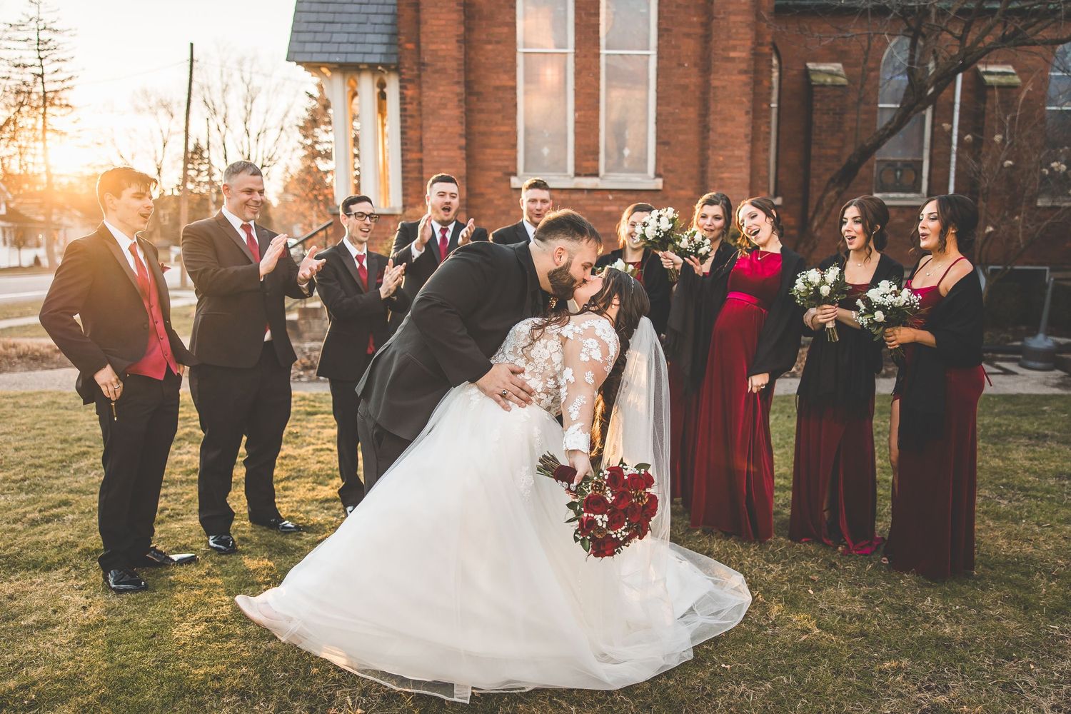 Golden hour wedding photos with bridal party in formal attire outside church.