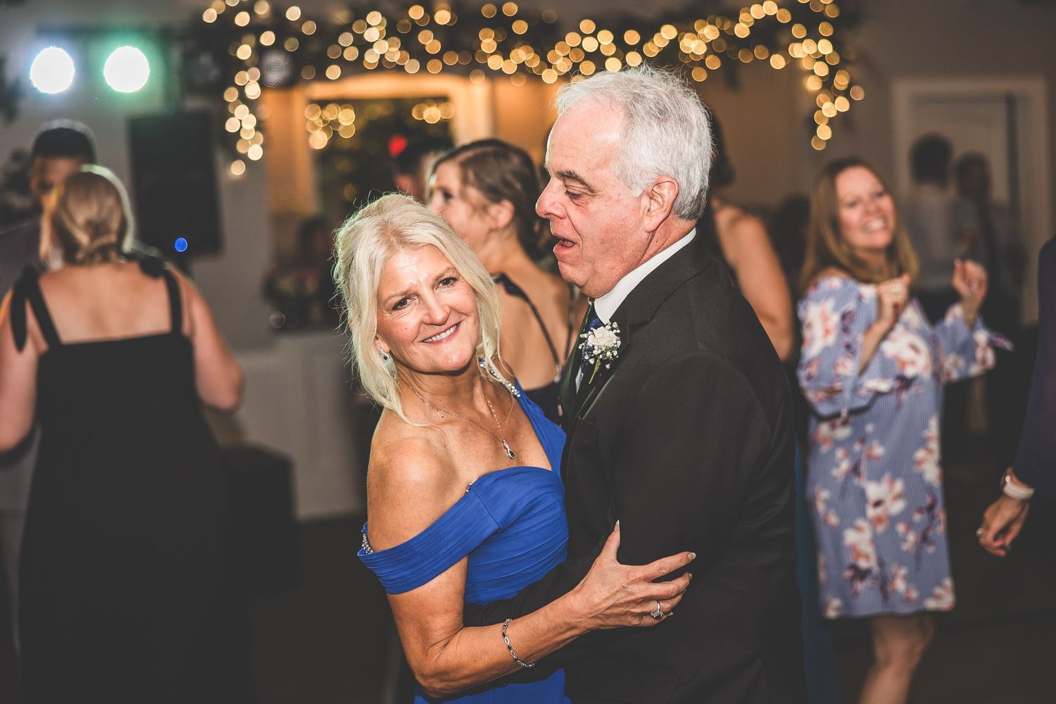 Wedding reception dance floor filled with guests enjoying evening celebration.