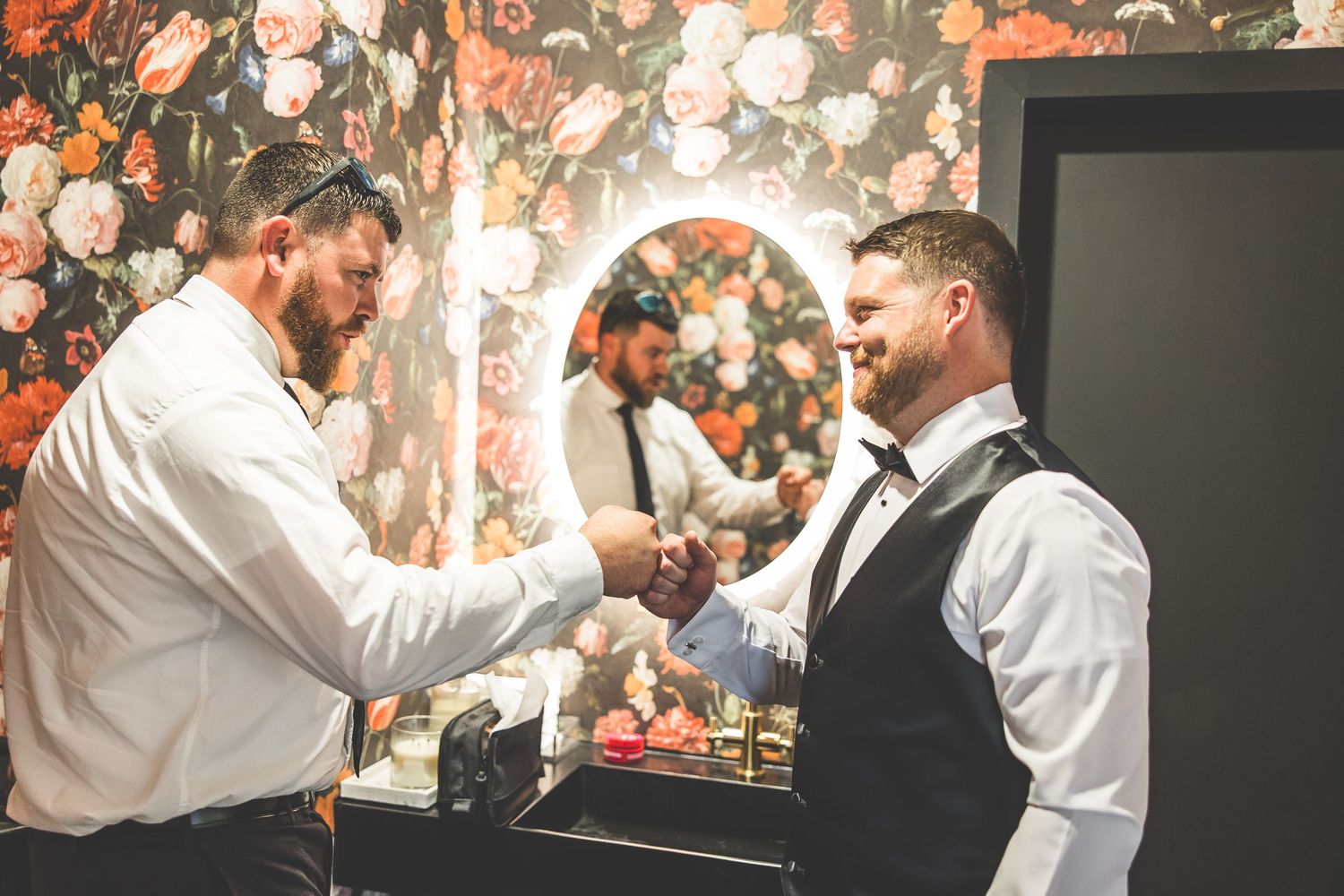 Wedding preparation scene with formal attire and floral backdrop.