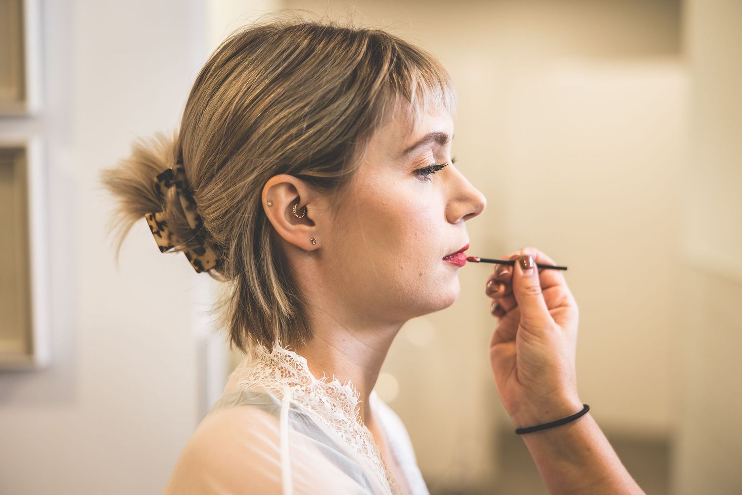 Wedding makeup application in progress with soft natural lighting.