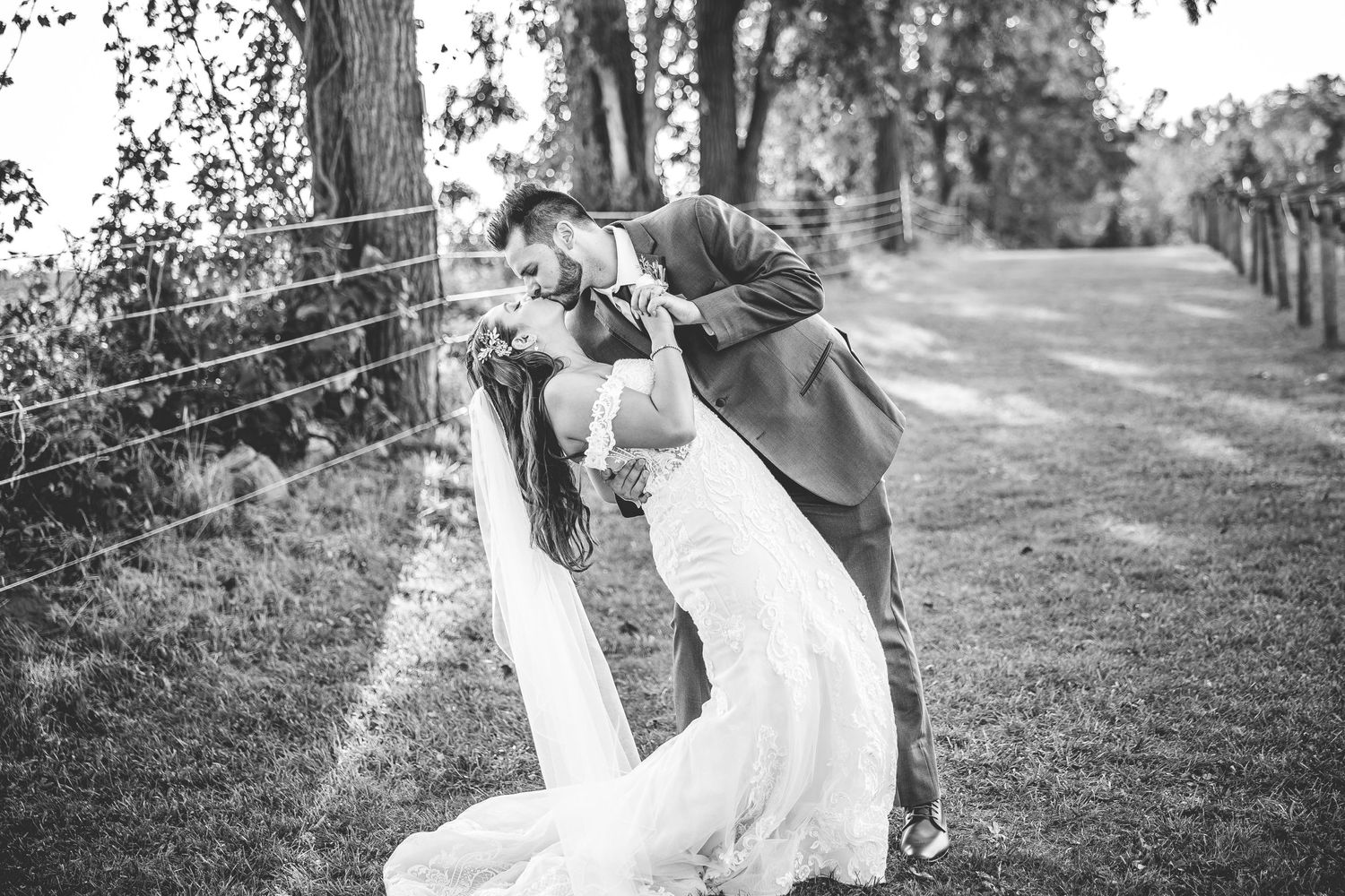 Black and white wedding photos captured in a rustic outdoor setting.