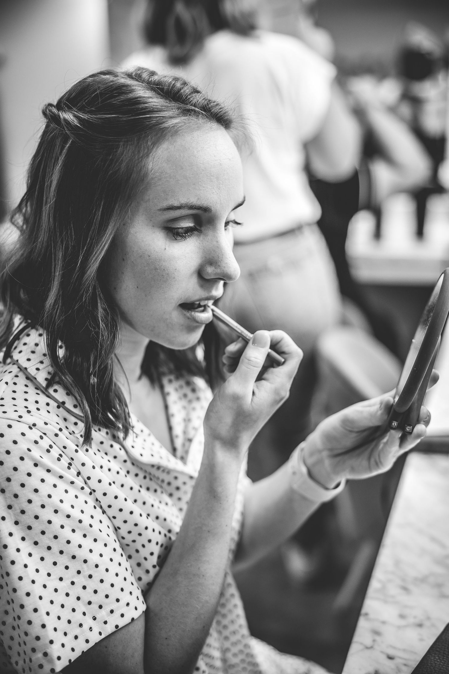 Black and white candid photo of person in polka dot dress.