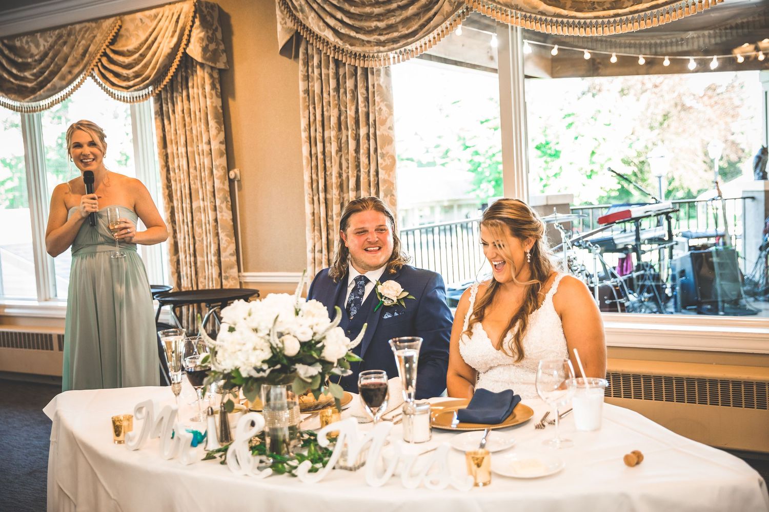 Wedding reception hall decorated with elegant curtains and table settings.