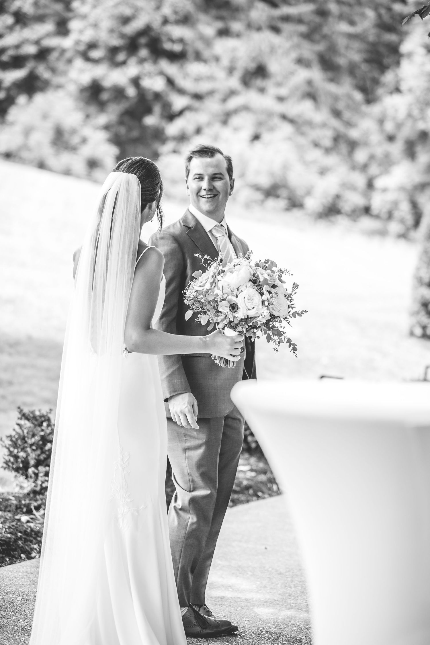Black and white wedding portraits captured in elegant outdoor garden setting.