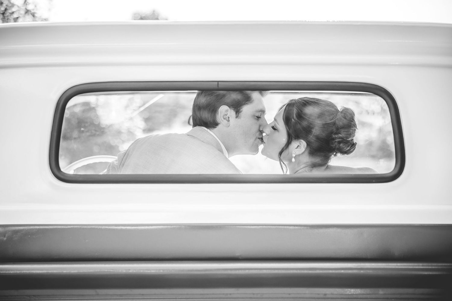 Artistic black and white series of wedding moments viewed through car mirrors and windows.