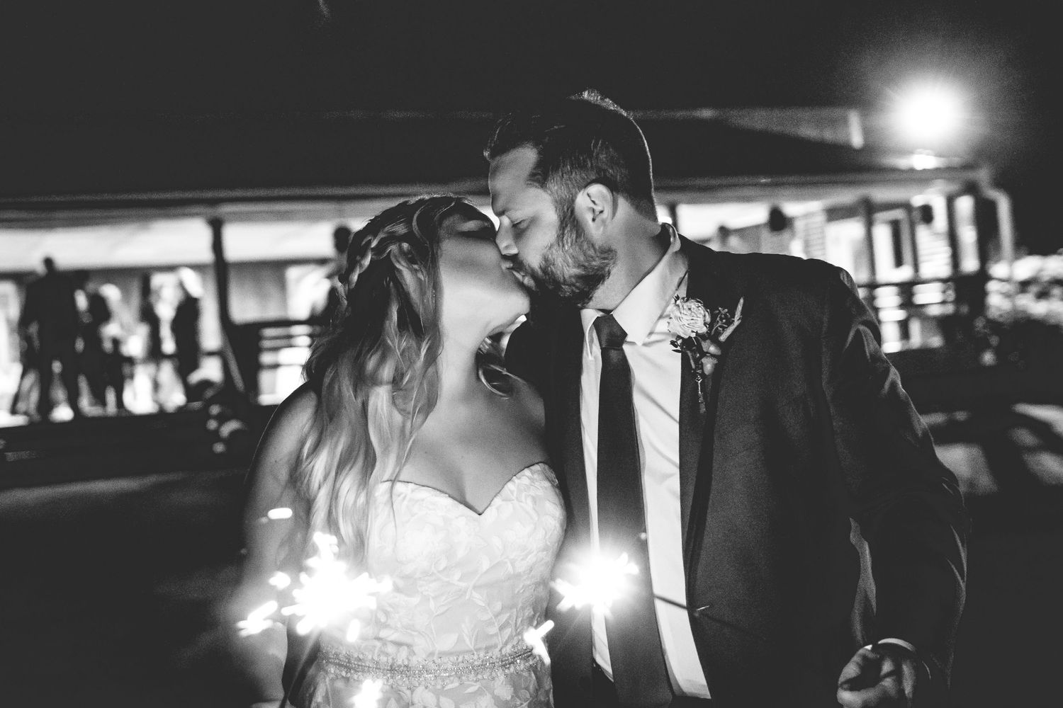 Dramatic nighttime silhouettes of wedding couples dancing under spotlights.