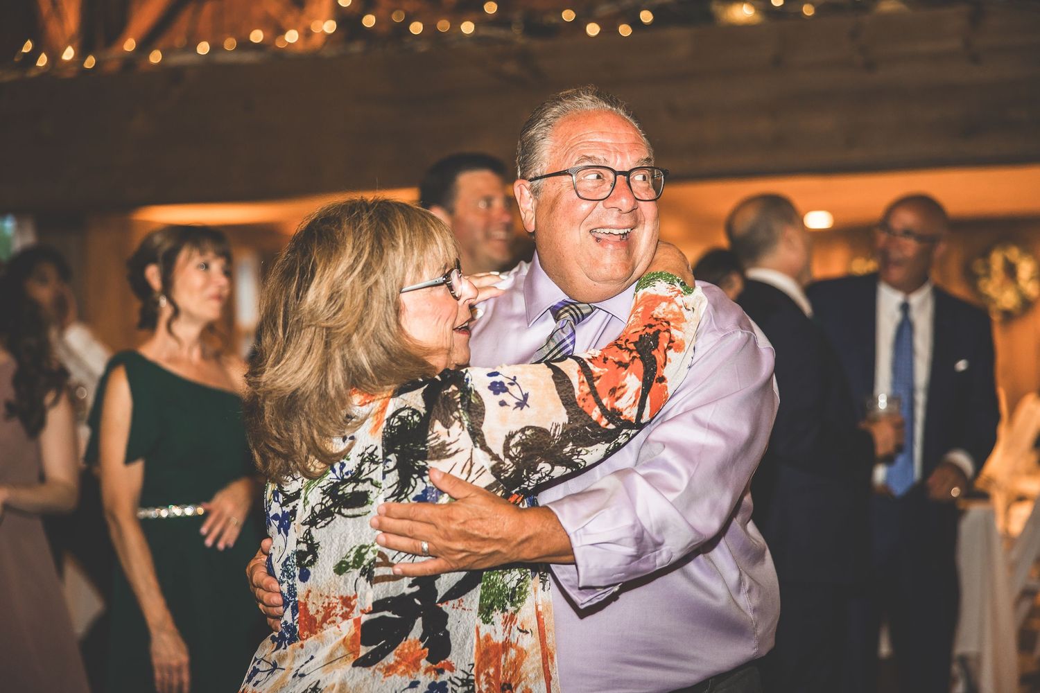 Wedding celebration in a rustic barn venue with string lights creating a warm ambiance.